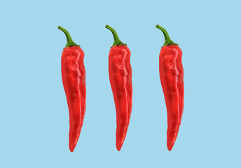 Flat lay red chili peppers pattern on ligh blue t background. Top view. Abstract
