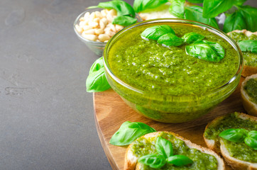 Pesto sauce and sliced bread on a stone table