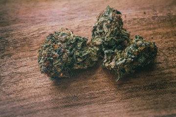 Darth Vader OG strain of cannabis indica marijuana on a wooden surface.