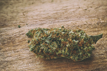 Super Lemon Haze strain of cannabis sativa marijuana on a wooden surface.