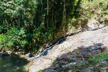 Naklejka na ściany i meble Hidden Waterfall in the tropical jungle on Langkawi island, Malaysia. Travel concept.