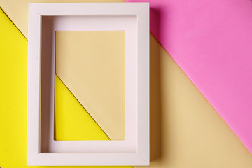 Mockup. Minimalism style. White empty picture frame against; abstract colored paper background; flat lay, copy space.