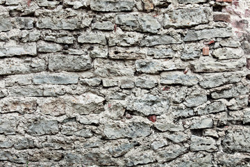 Old wall made of stones and broken bricks. Vintage rough blocks surface background