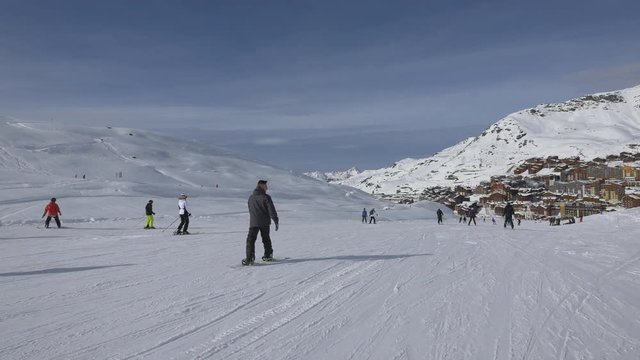 People riding snowboards and skiing