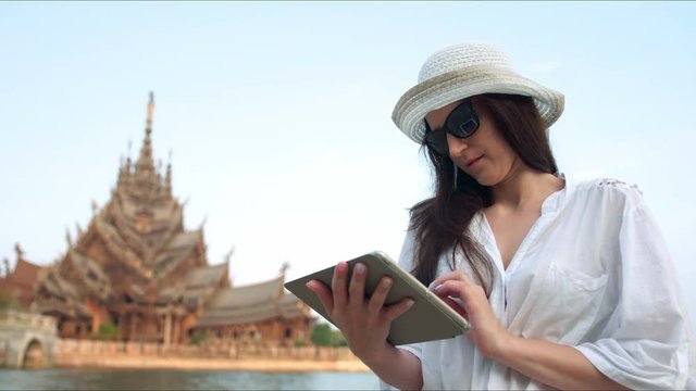 Young woman traveler using digital tablet computer reading guidebook app searching information