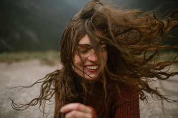 Woman Smiling With Wind Blowing Her Long Hair Around Her Face
