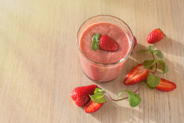 Strawberry Banana Smoothies in Glasses with Ingredients on light wooden Table