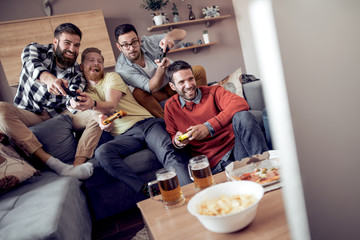 Friends enjoying playing video games at home