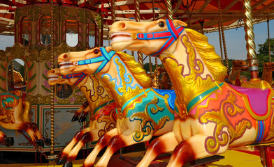 Three colourful carousel horses