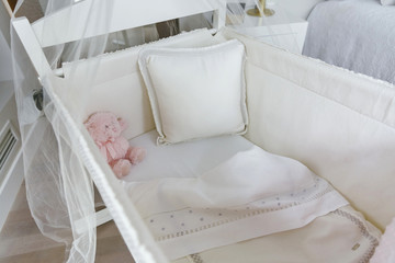 Fototapeta na wymiar Top view of crib with canopy, sheets, cushion and teddy bear
