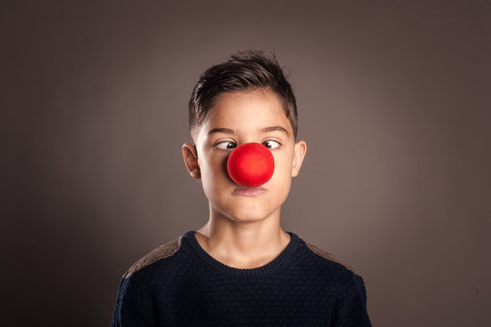 Kid With A Clown Nose On A Gray Background