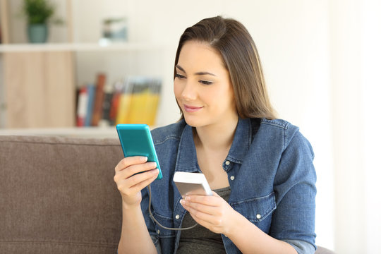 Girl Charging A Smart Phone With A Portable Charger