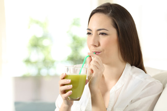 Girl drinking vegetable juice sipping a straw