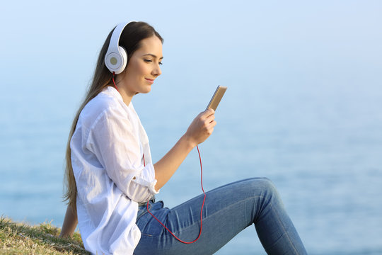 Girl listening to online music on the beach