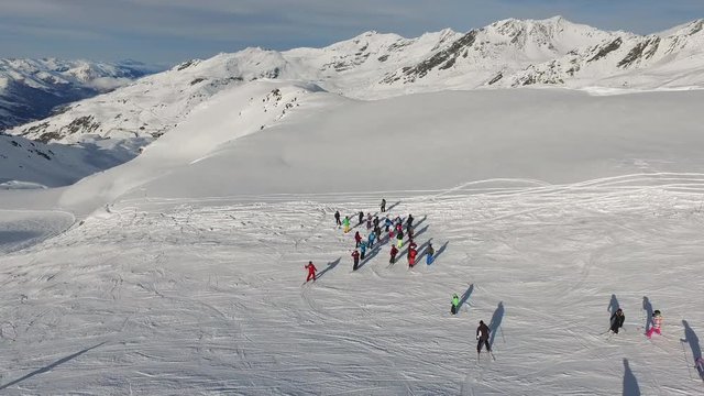 Aerial view of people skiing and standing on a slope