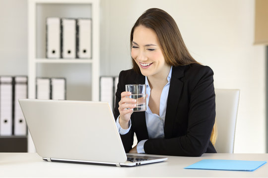 Office worker working holding a glass of water