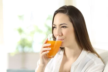 Photo sur Aluminium Jus Woman drinking orange juice in a glass