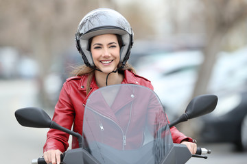 Woman driving a scooter on the street © Antonioguillem