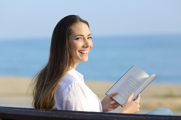 Woman holding an open book looking at camera