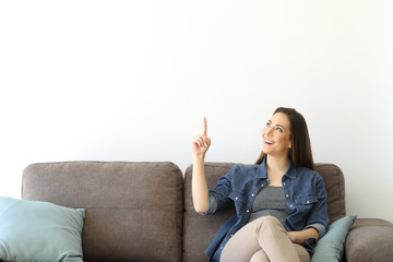 Woman on a couch pointing above