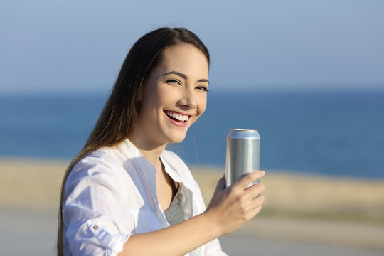 Woman holding a refreshment can looking at camera
