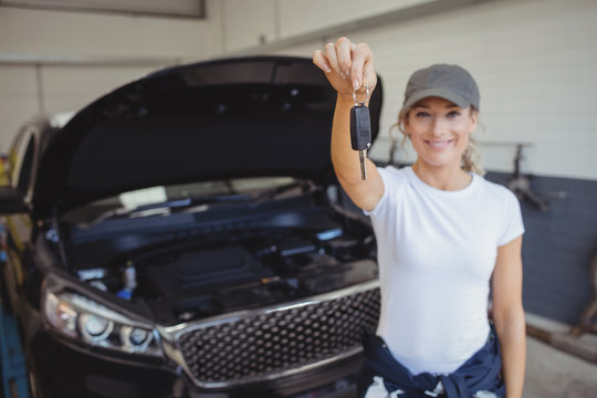 Female mechanic in garage holding car key