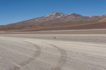 Fototapeta na wymiar Unpaved Road in Altiplano of the Siloli desert, part of the Reserva Eduardo Avaroa, Bolivia - at an altitude of 4600m near the border of Chile and the Atacama desert, South America