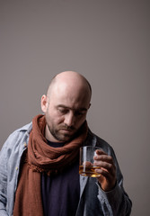 depressed bald man with alcohol glass