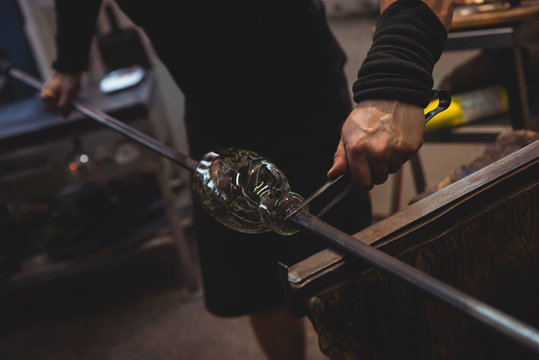 Glassblower shaping a molten glass