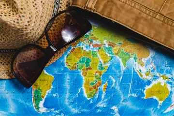 Schilderijen op glas Adventure. Hat, Glasses and Brown Jeans on map. Top view. Travel Concept. © MaximBeykov