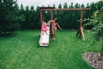 the girl descends from a wooden children's slide