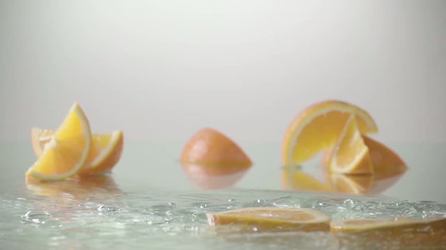 rolling orange fruit slices on white background . Slow motion shot