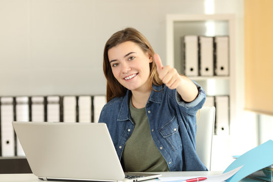 Satisfied intern with thumbs up at office