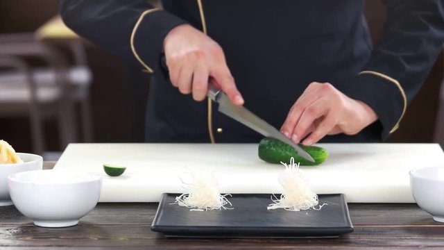 Chef cutting a cucumber. Fresh vegetable and kataifi dough.