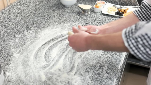 Hands of chef and dough. Cooking table, flour.