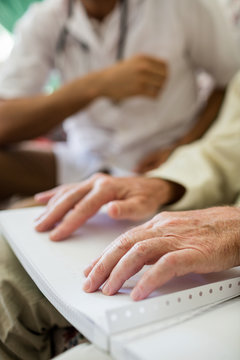 Blind senior man using braille to read
