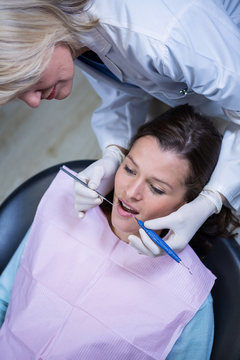 Dentist examining a patient with tools 