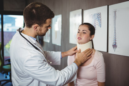 Physiotherapist examining a female patient's neck