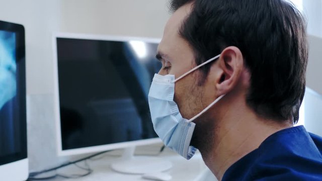 Man dentist looking at x-ray in private practice.