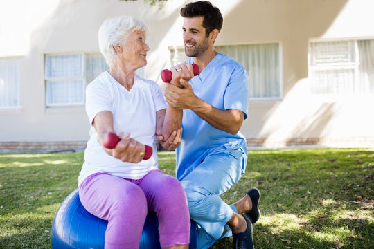 Nurse helping senior woman doing exercices