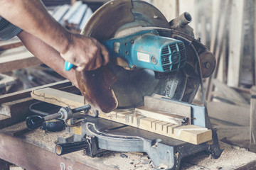 Background image of woodworking workshop: carpenters work table with different tools and wood cutting stand, vintage filter image