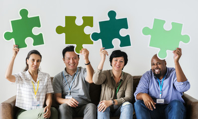 Group of co-workers holding puzzle icons