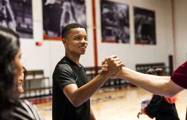 Group of teenager friends on a basketball court giving each other a high five