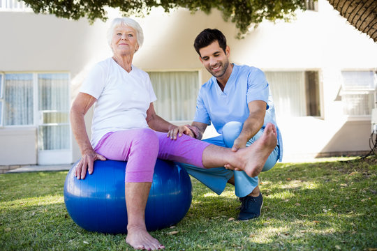 Nurse helping senior woman doing exercises 