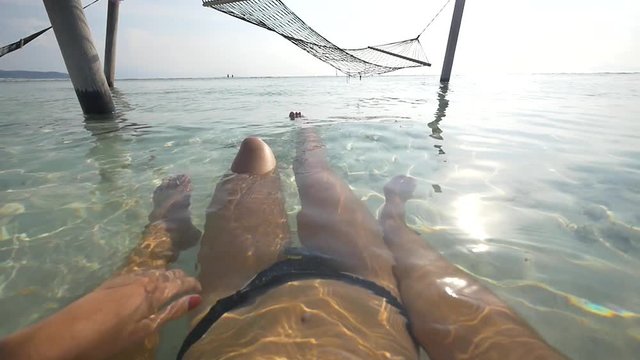 POV of young woman relaxing with boyfriend in shallow ocean waters