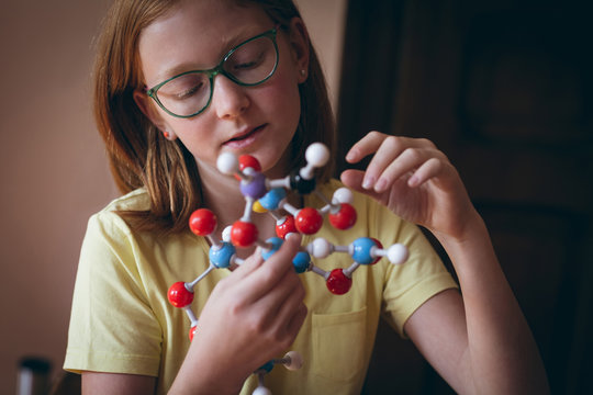 Attentive girl experimenting with molecule
