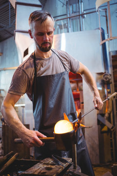 Glassblower forming and shaping a molten glass