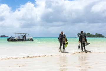 Divers Walking on Beach in Seychelles.