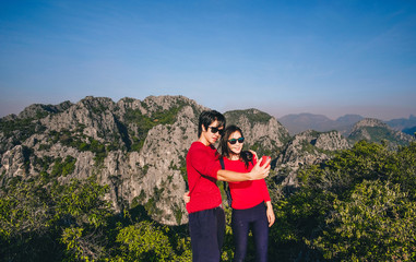 couple traveler standing on top of the mountain and enjoying for beautiful nature view on holiday.adventure concept.