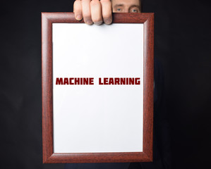 In the hands of a businessman a frame with the inscription:MACHINE LEARNING